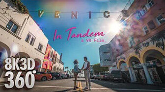 In Tandem: a couple on a Venice Beach street under the Venice sign.